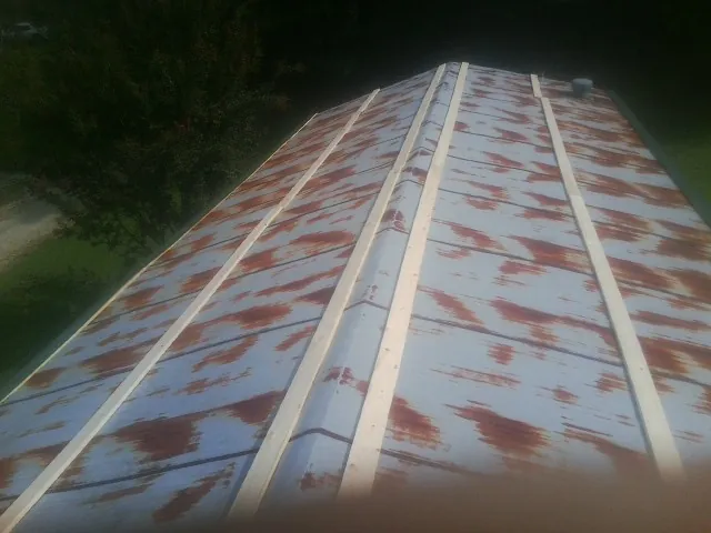 Rusted metal roof panels with new wood purlins before replacement — Storm Damage Roof Repair in Canal Fulton by Roofing Brothers