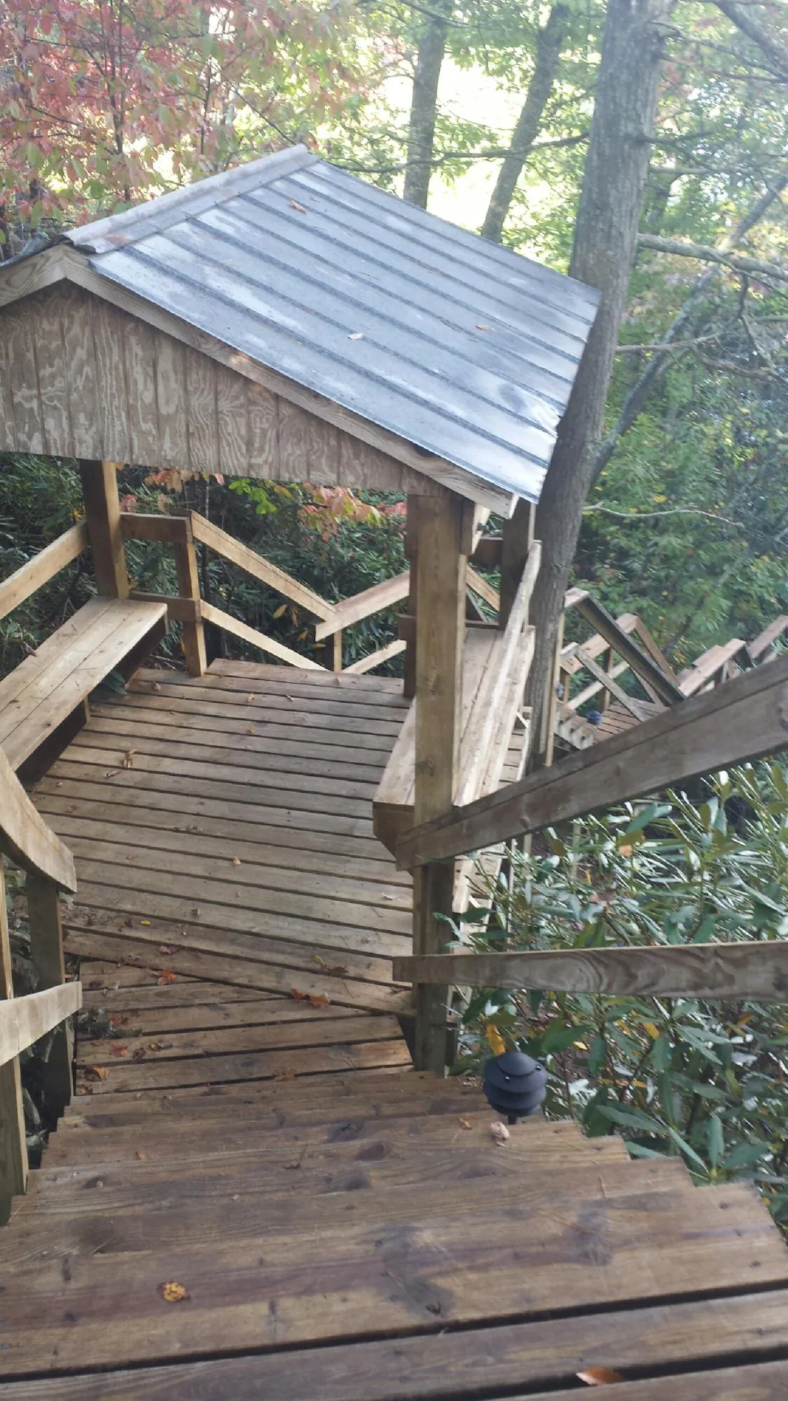 Metal roofed shelter over wooden steps on a wooded walkway — Skylight Repair & Installation work by our crew in Canal Fulton