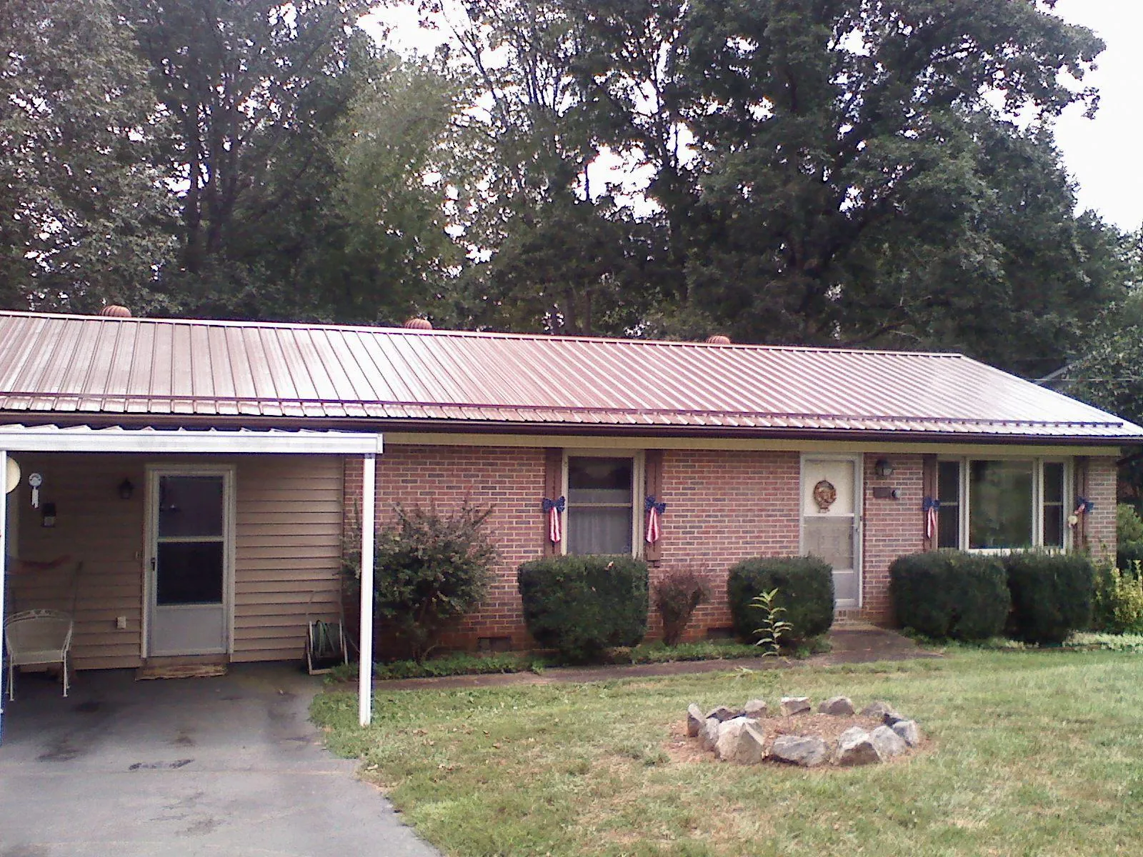 Bronze metal roof and carport on a brick ranch home — Roof Repair work by our crew in Canal Fulton