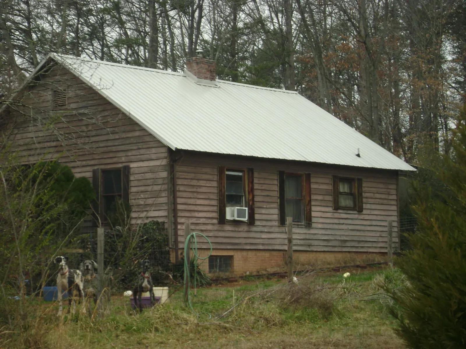 White metal roof on an old wood sided farmhouse, from a Metal Roof Installation job in Canal Fulton